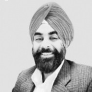 A trusted financial professional, a man with a beard wearing a turban and suit jacket, is smiling while facing the camera against a plain background.